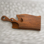 Set of two natural wooden serving boards with sculpted curved cut-outs and handles