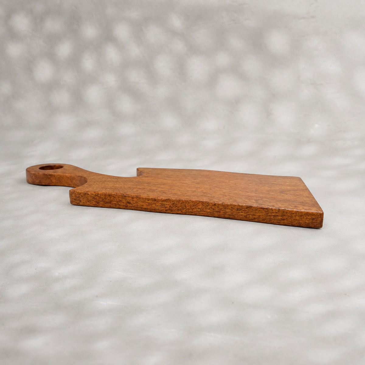 Set of two natural wooden serving boards with sculpted curved cut-outs and handles