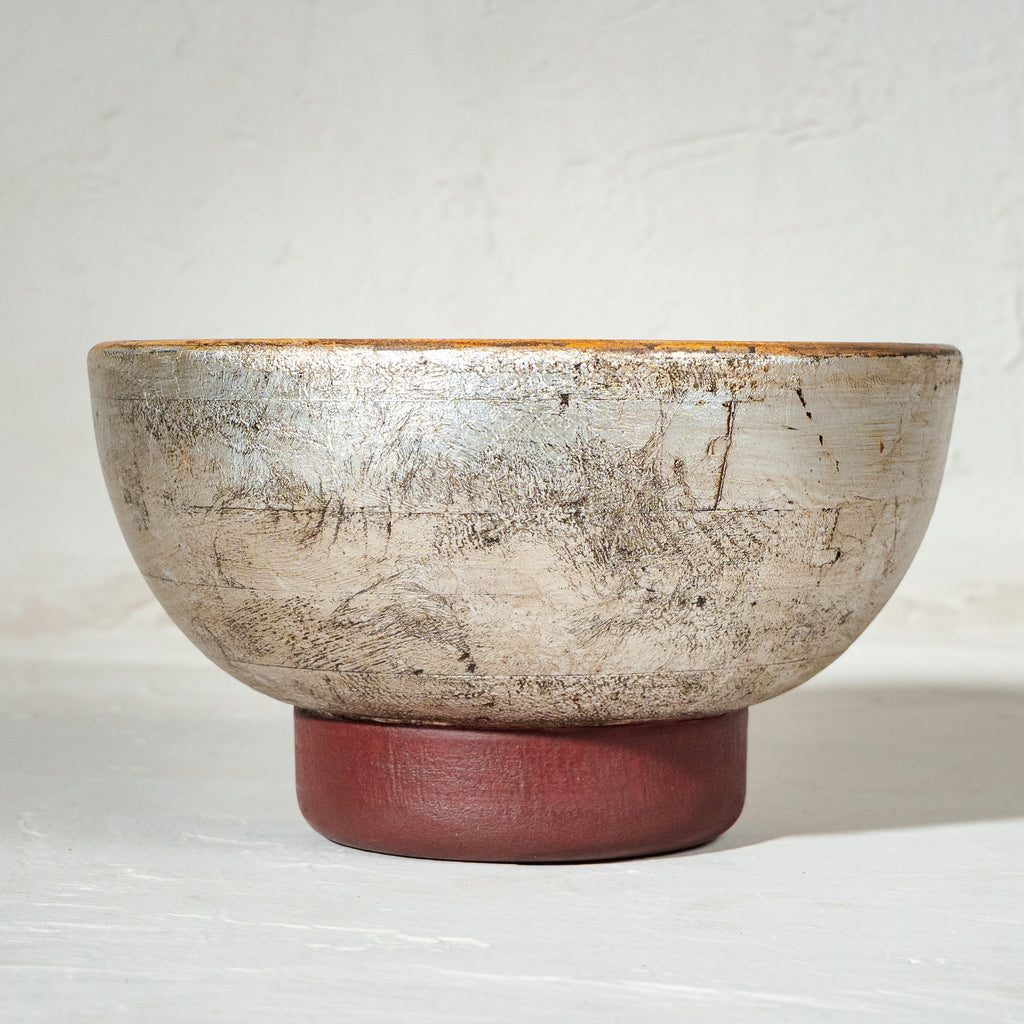 Warm silver wooden serving bowl with a red pedestal base