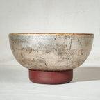 Warm silver wooden serving bowl with a red pedestal base