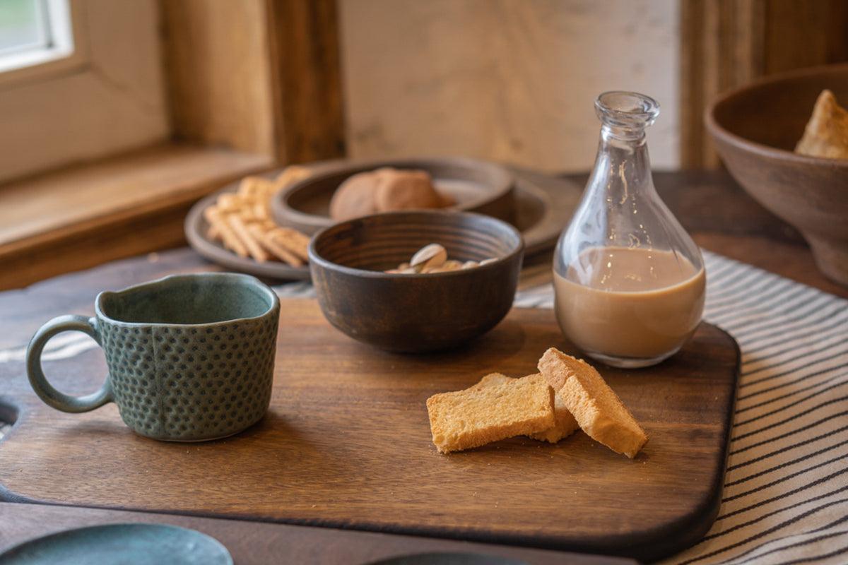 Orbit wooden nut bowl styled with tableware and snacks