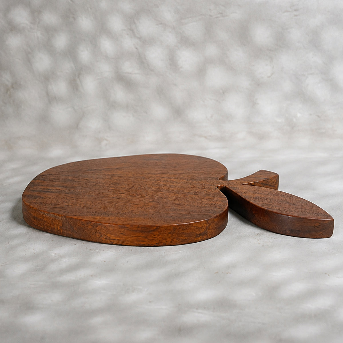 Apple-shaped natural wooden trivet with a carved leaf