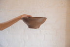 Oro wooden serving bowl held in one hand