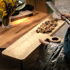 Oversized wooden cheese board styled with food