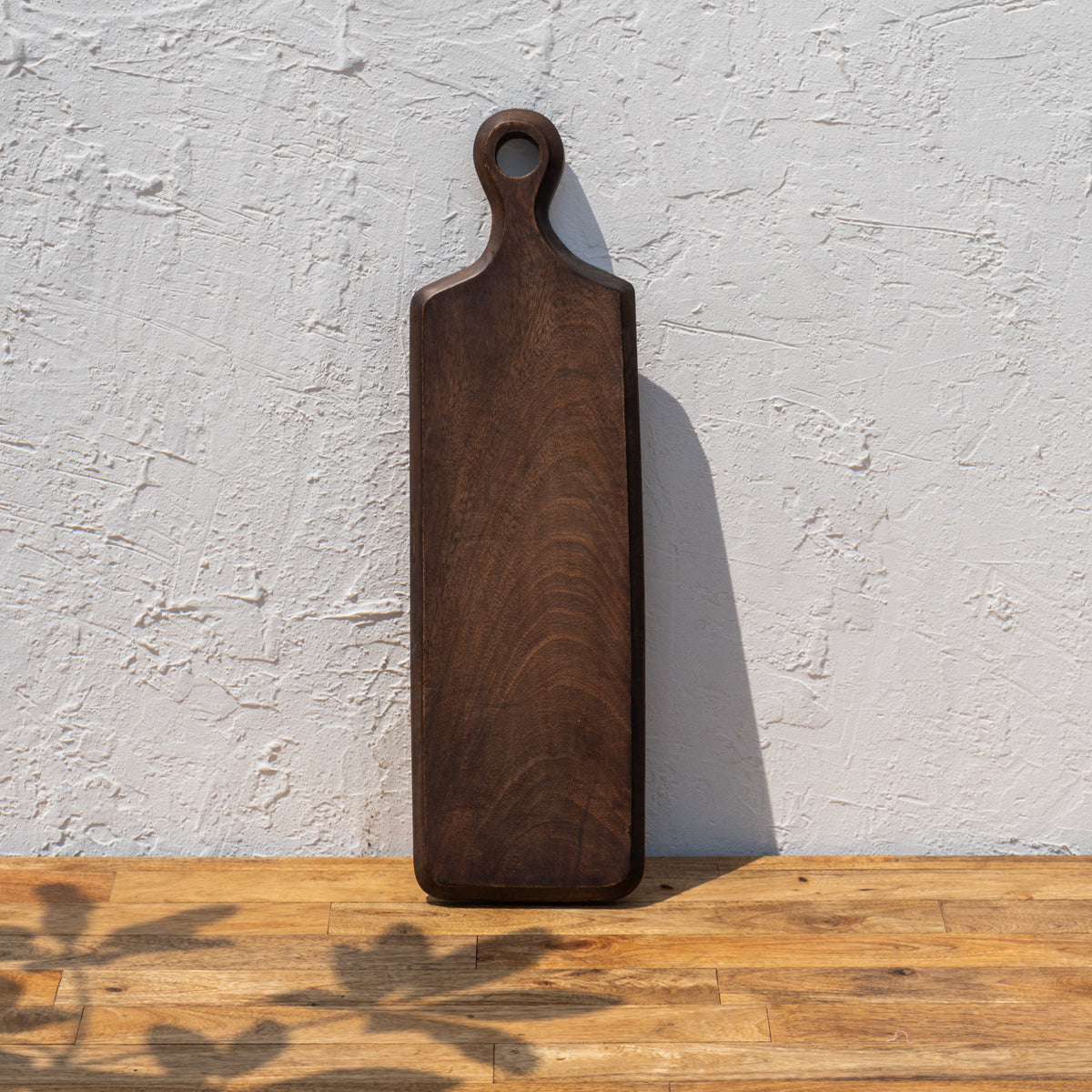 Paddle wooden cheese board standing upright