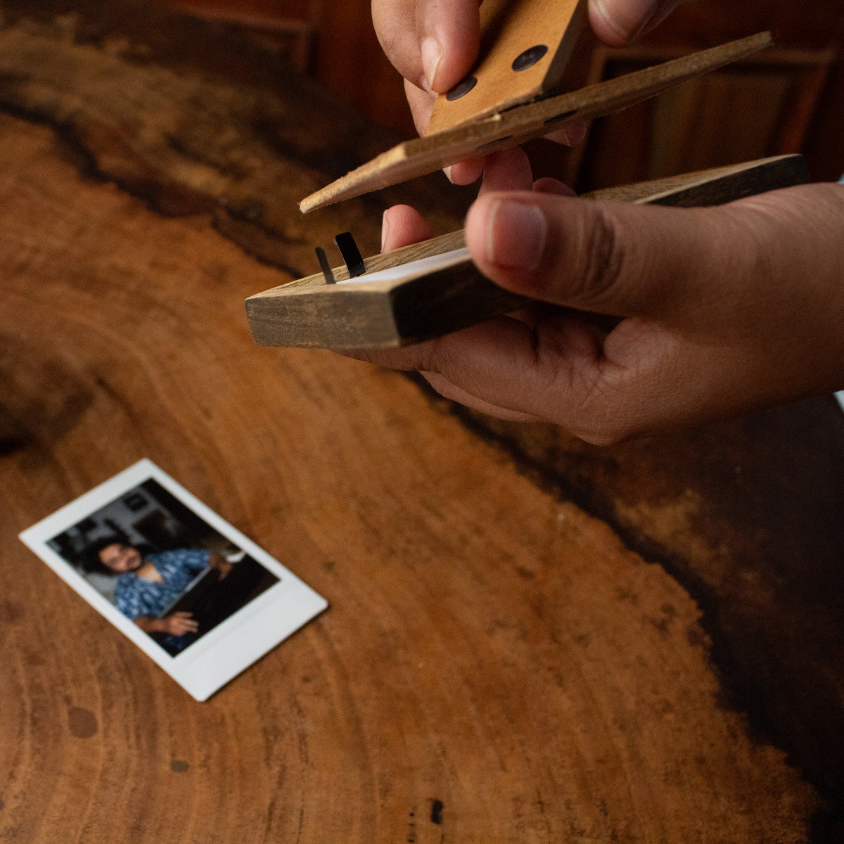 Side view of a wooden Polaroid photo frame with its easel stand open