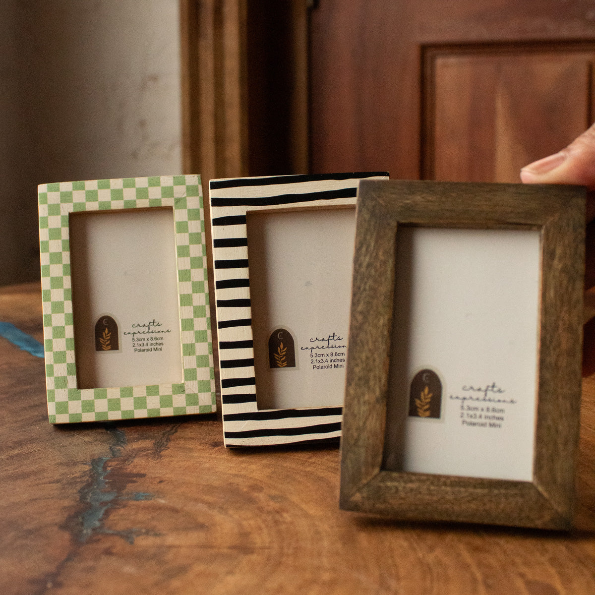 Set of three wooden Polaroid photo frames in green, striped and natural finishes