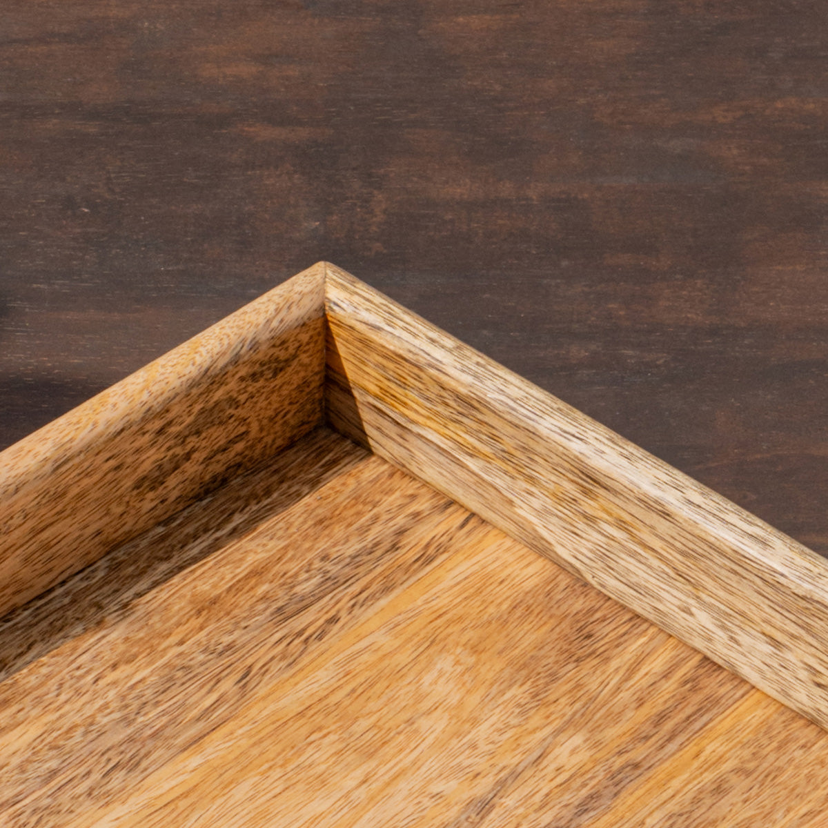 Close-up of the corner of the Essence wooden serving tray