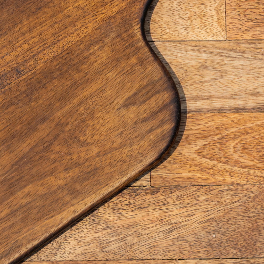 Close-up of the Glide chopping board's natural wood grain and rounded edge