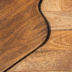 Close-up of the Glide chopping board's natural wood grain and rounded edge