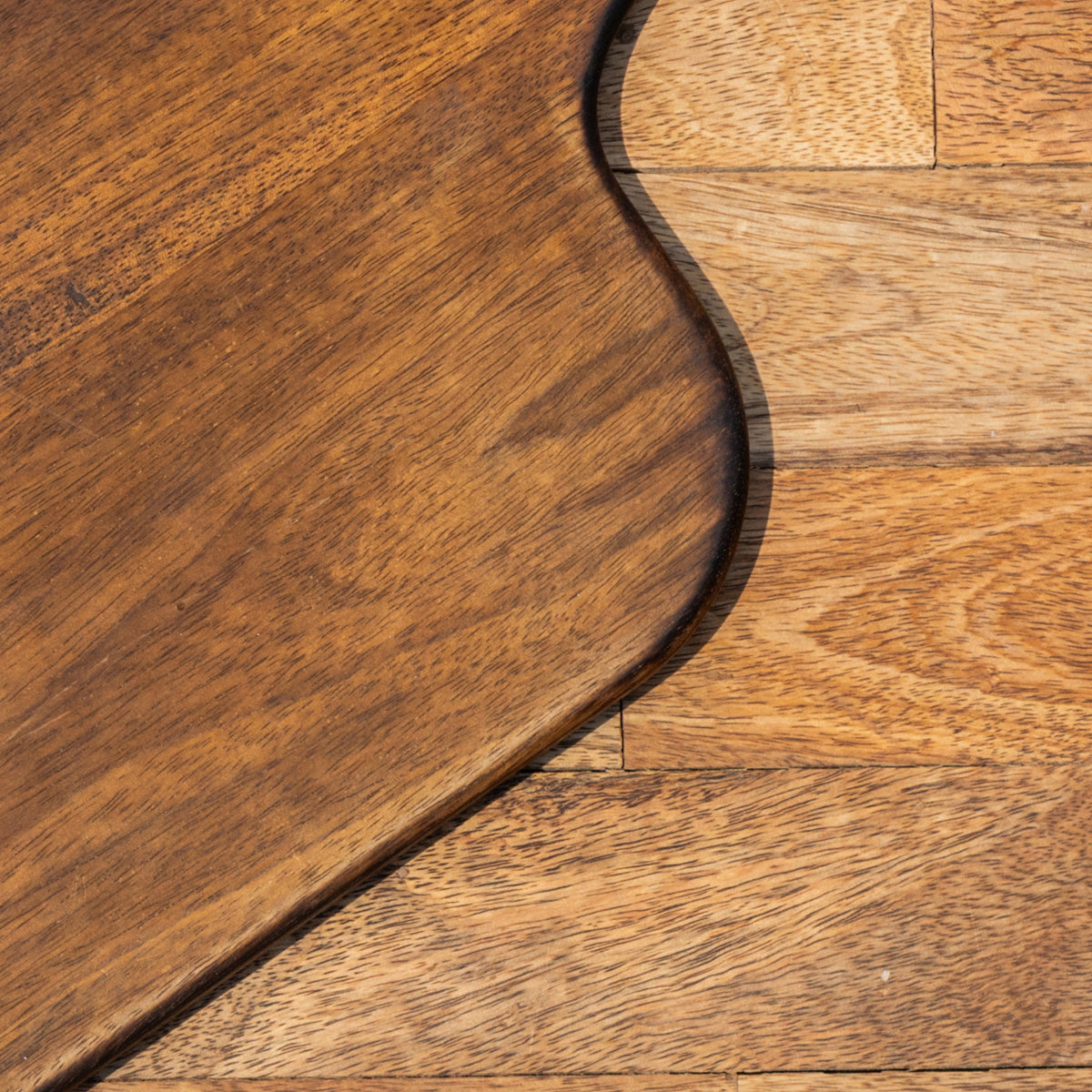 Close-up of the Glide chopping board's natural wood grain and rounded edge