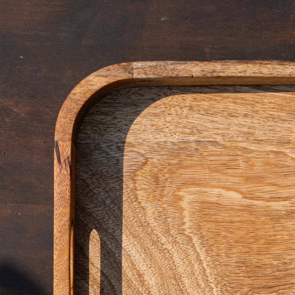 Close-up of the rounded corner of the Glide wooden serving tray