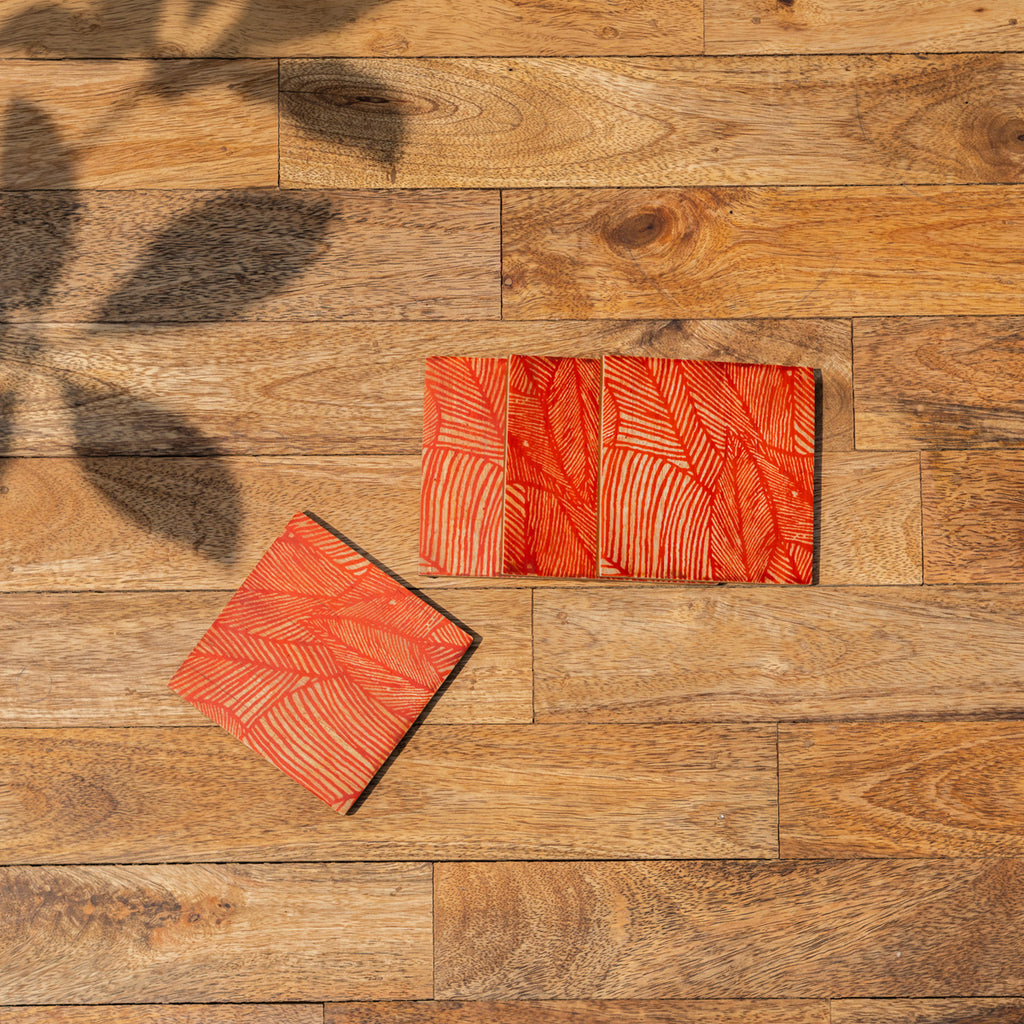 Palash printed coasters spread across a wooden surface
