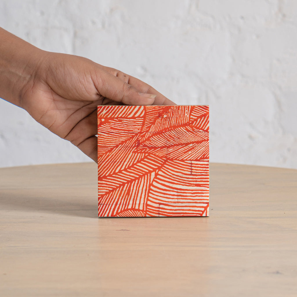 Palash printed coaster held in one hand