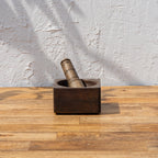 Trunk wooden mortar and pestle standing on a natural wood surface