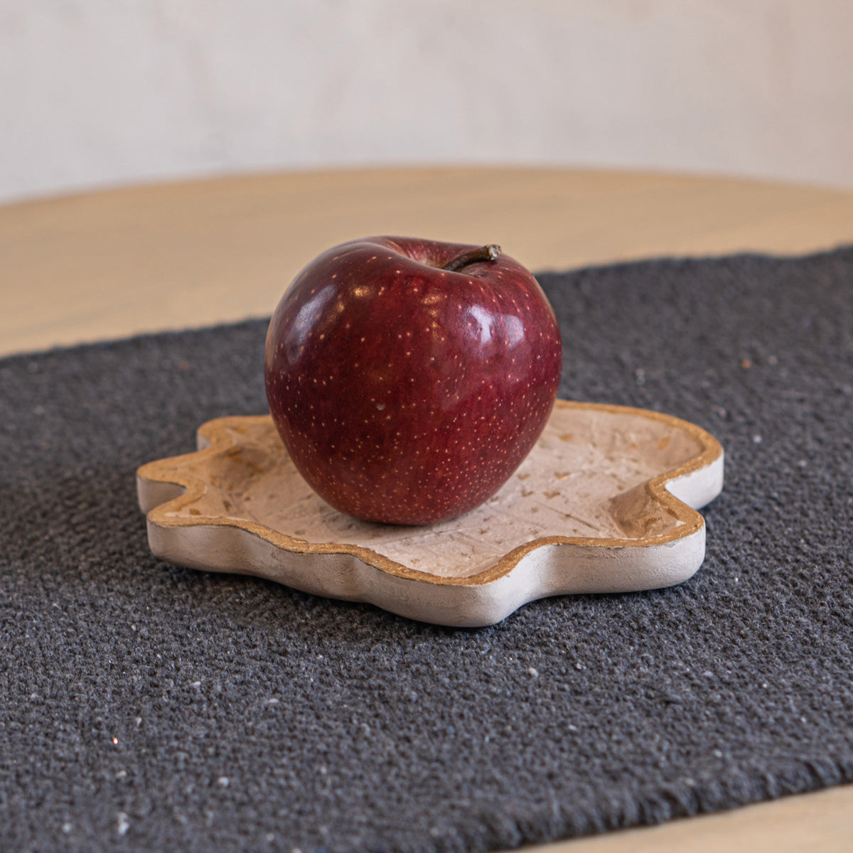 Twister trinket tray holding a red apple