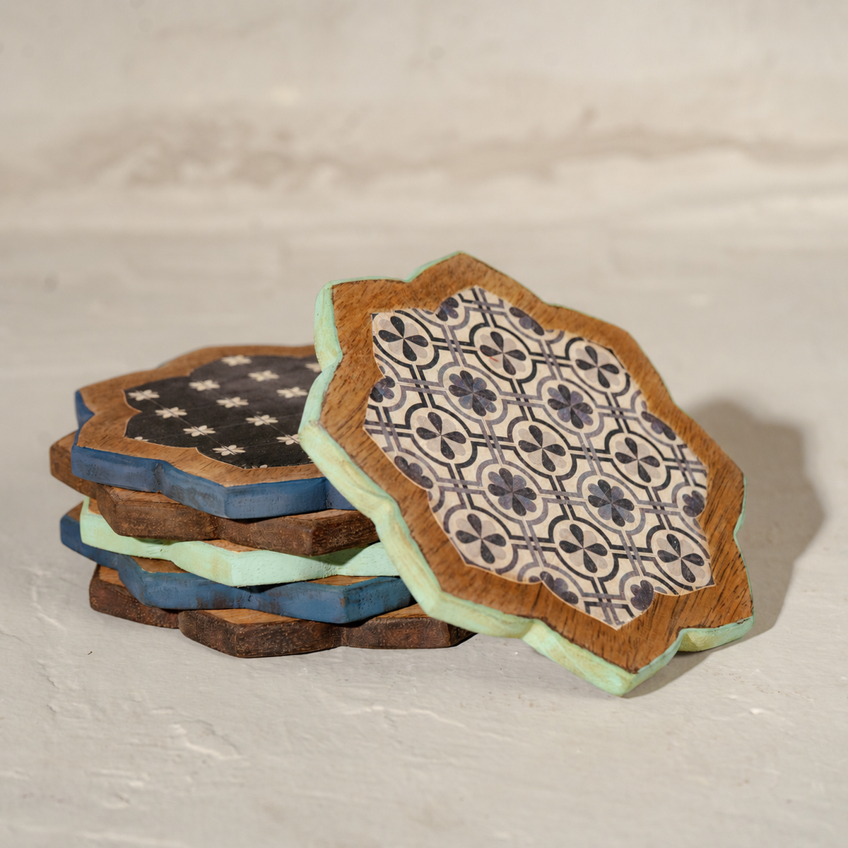 Stacked Kasida wooden coasters showing varied blue patterns