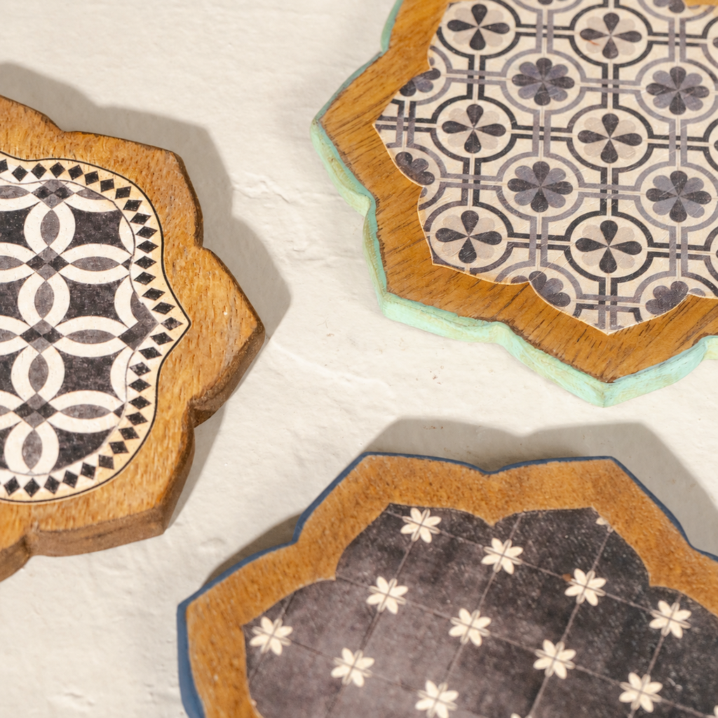 Close-up of three Kasida wooden coasters with printed patterns