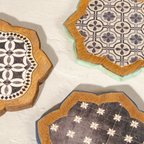 Close-up of three Kasida wooden coasters with printed patterns