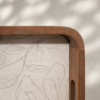 Close-up of the rounded corner and handle of a Mehfil wooden serving tray