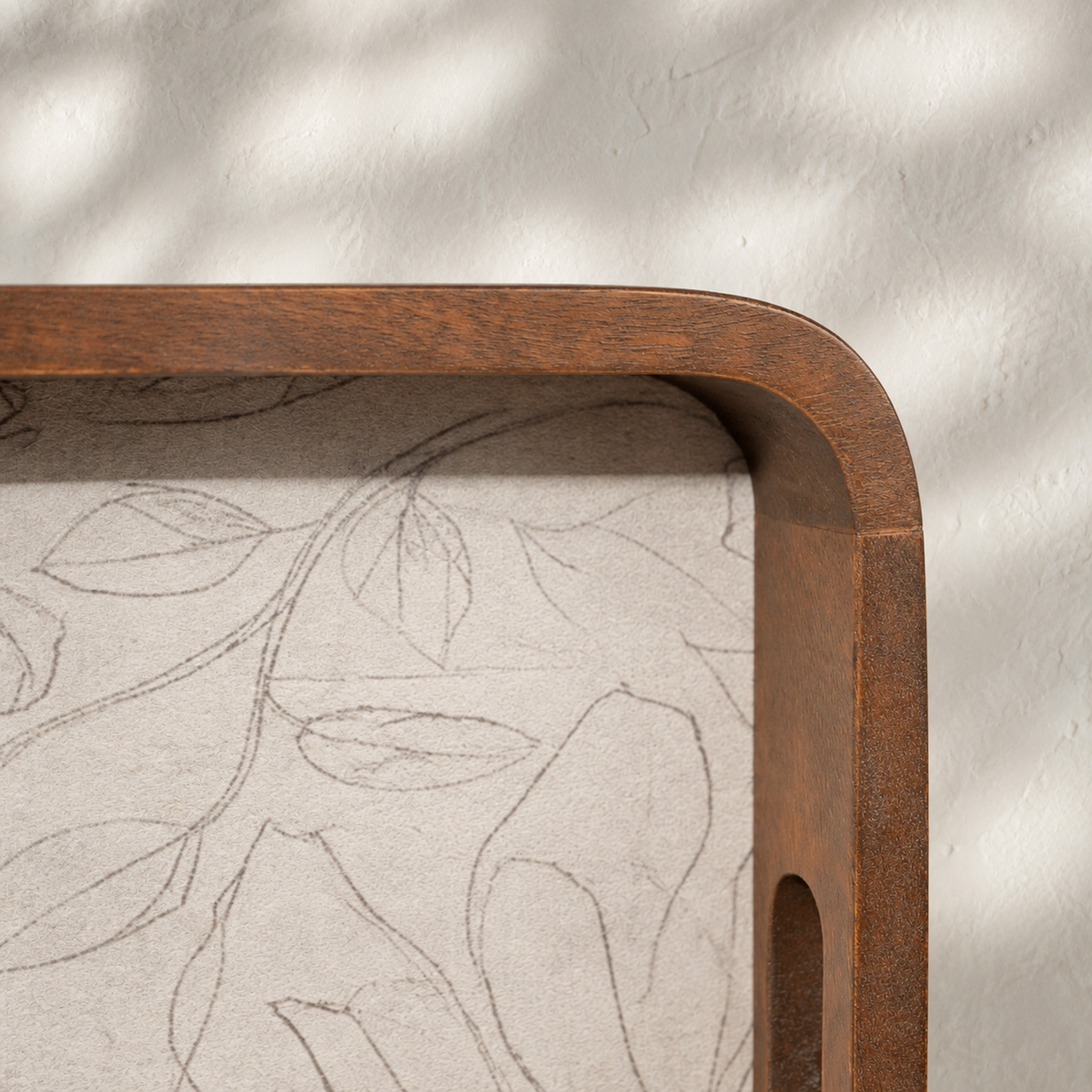 Close-up of the rounded corner and handle of a Mehfil wooden serving tray