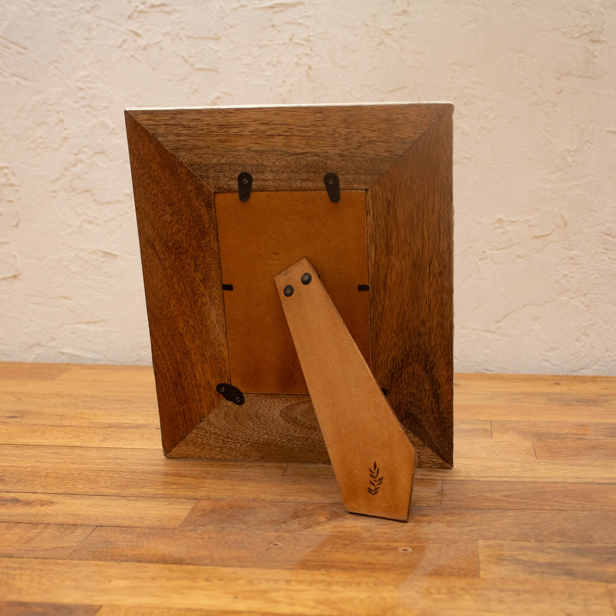 Back view of the Waves wooden photo frame displayed vertically with easel stand