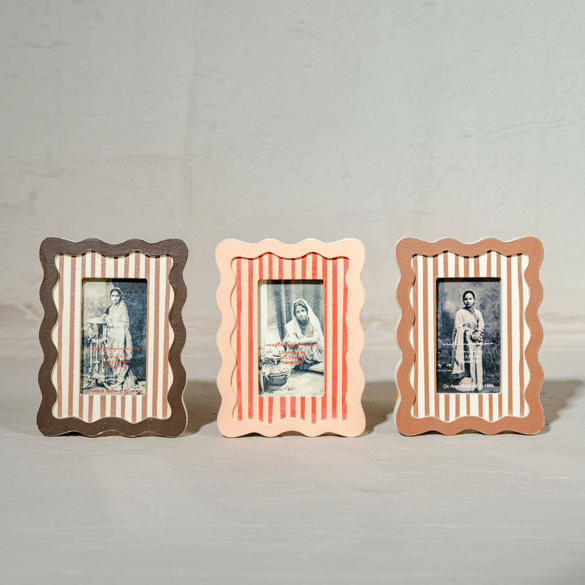 Set of three wavy wooden Instax Mini photo frames in taupe peach and warm red