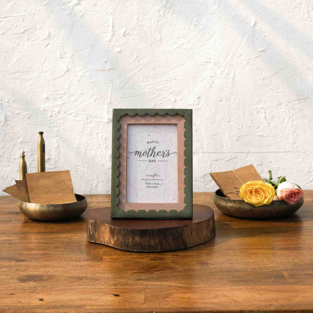 Olive and pink wavy wooden photo frame styled with brass décor and flowers