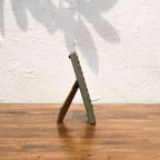 Side view of the olive and pink wavy wooden photo frame with easel stand