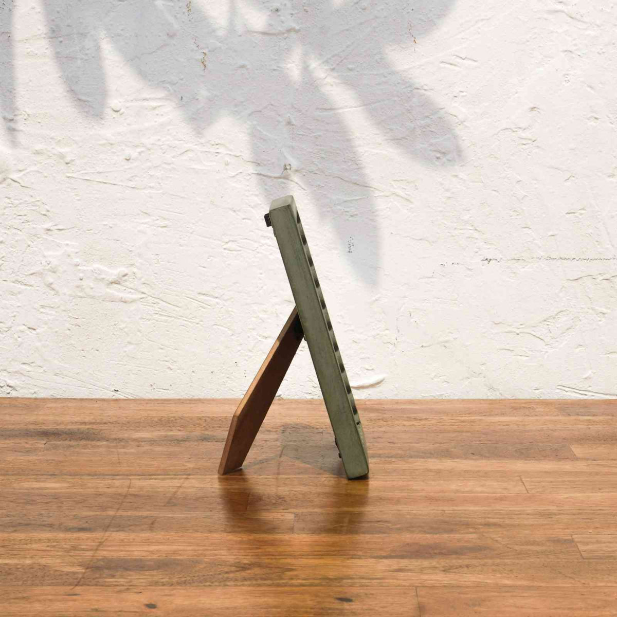 Side view of the olive and pink wavy wooden photo frame with easel stand