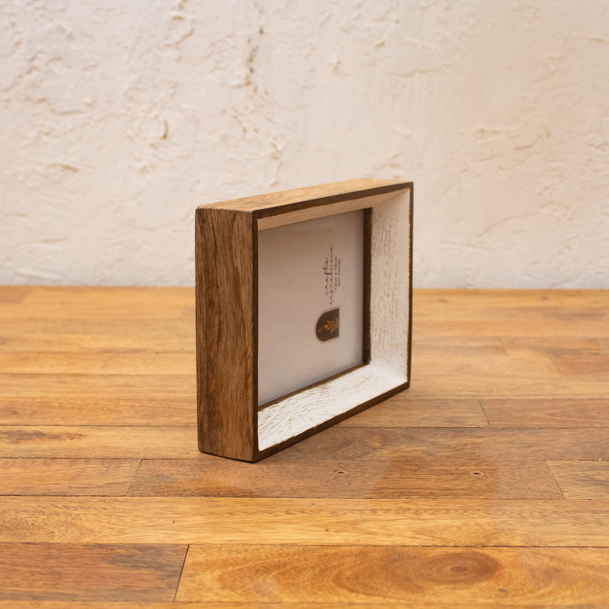 Angled side view of the Niche natural wood and white photo frame