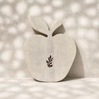 Front view of the whitewashed Orchard apple-shaped trivet with leaf motif