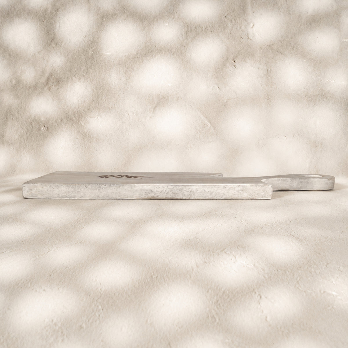 Side view of two whitewashed Freeform wooden serving boards