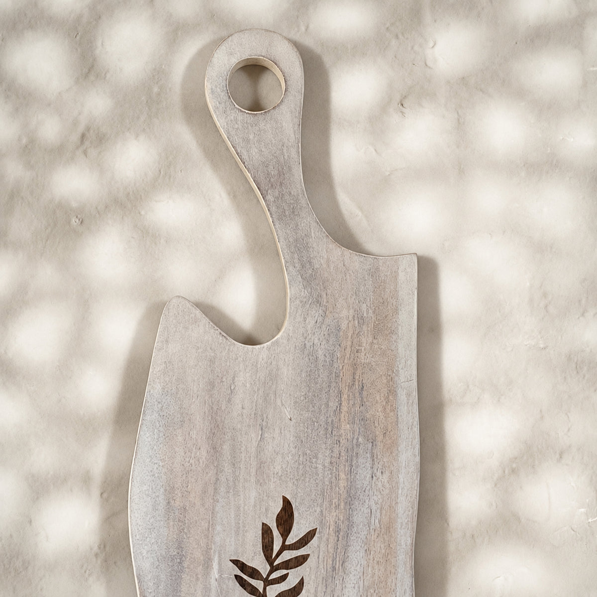 Close-up of the whitewashed Freeform wooden serving board with leaf motif