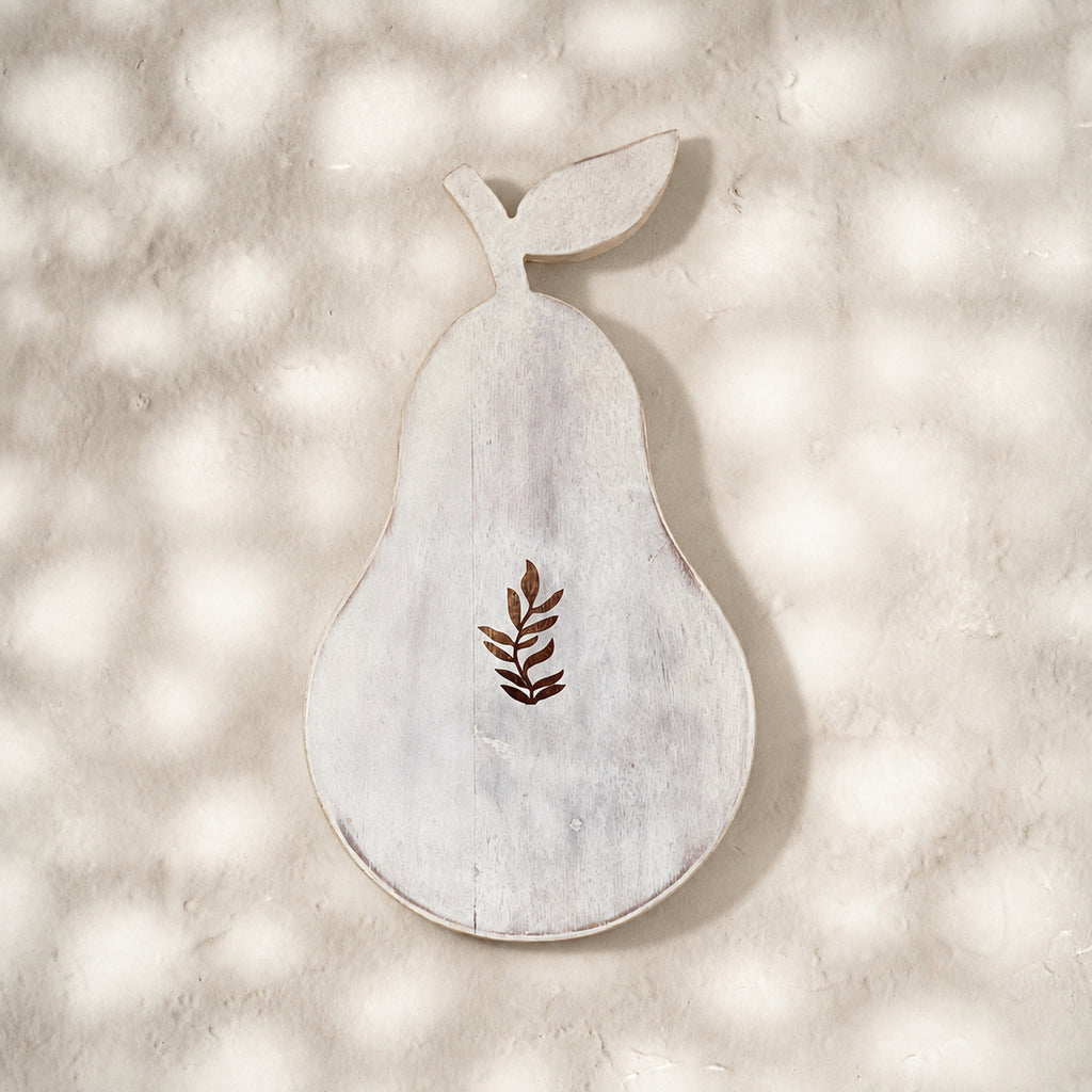 Front view of the whitewashed Orchard pear-shaped trivet with leaf motif