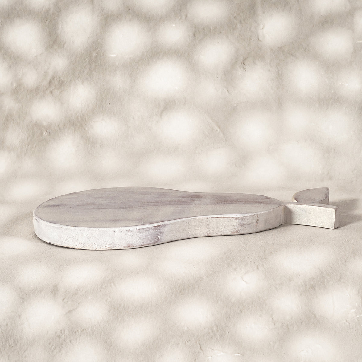 Low side view of the whitewashed Orchard pear-shaped wooden trivet
