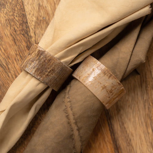 Basic horn napkin ring holding a folded beige napkin