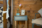 Niche small wooden photo frame displayed on a blue bedside cabinet