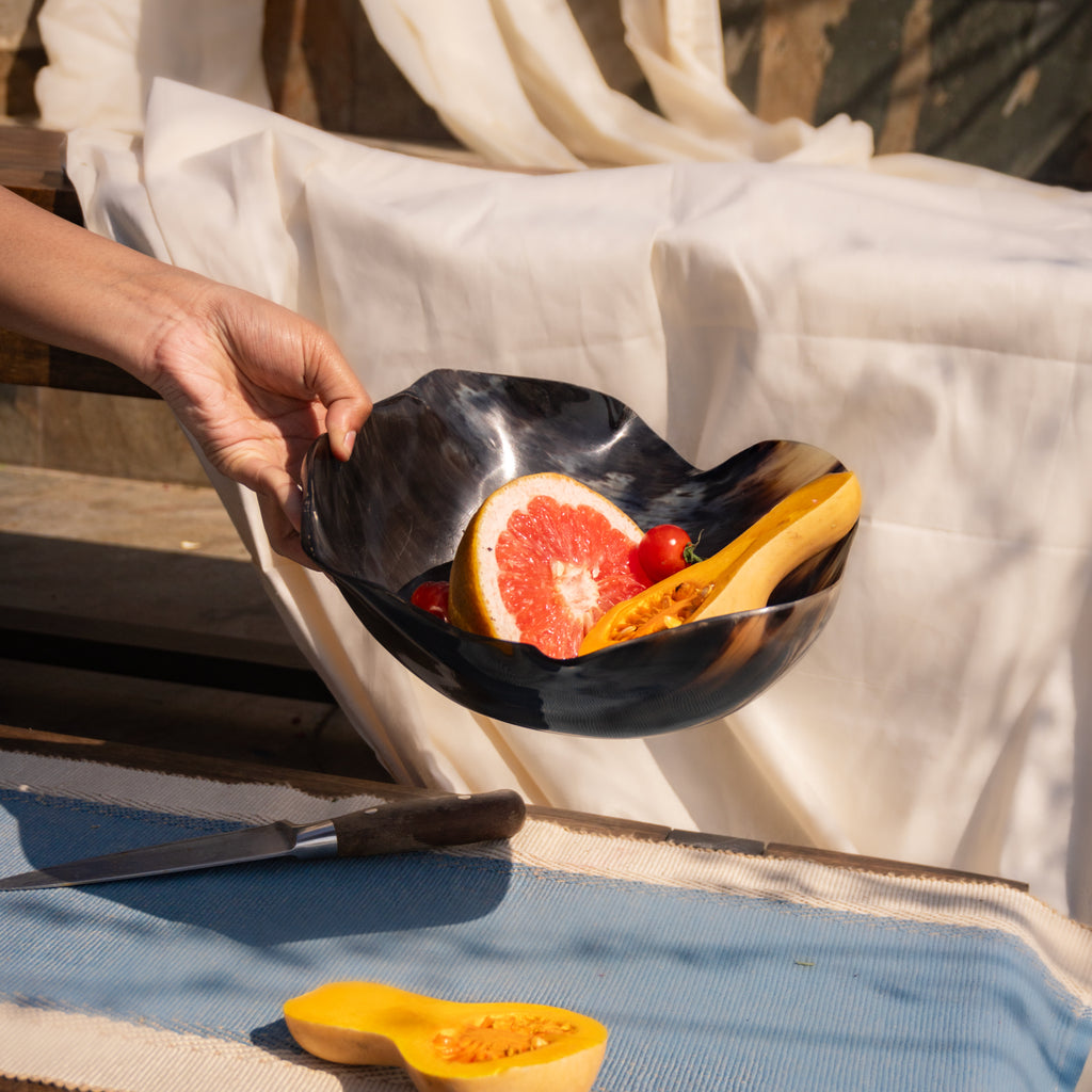 Fluted resin serving bowl held while filled with fruit