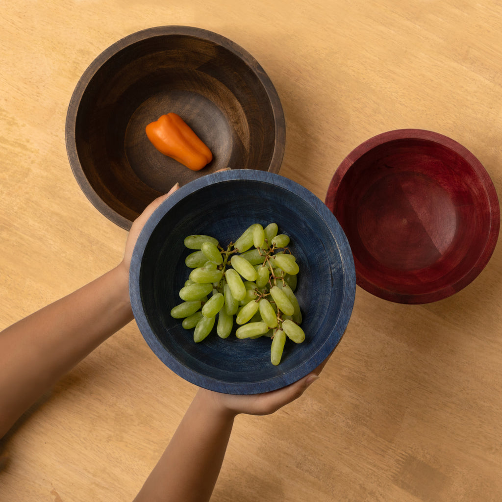 Top view of three large wooden bowls with vegetables