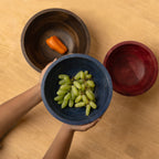 Top view of three large wooden bowls with vegetables