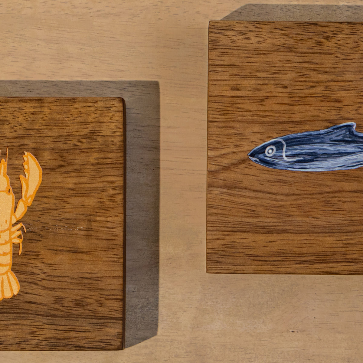 Close-up of two square Marine wooden trivets displayed side by side