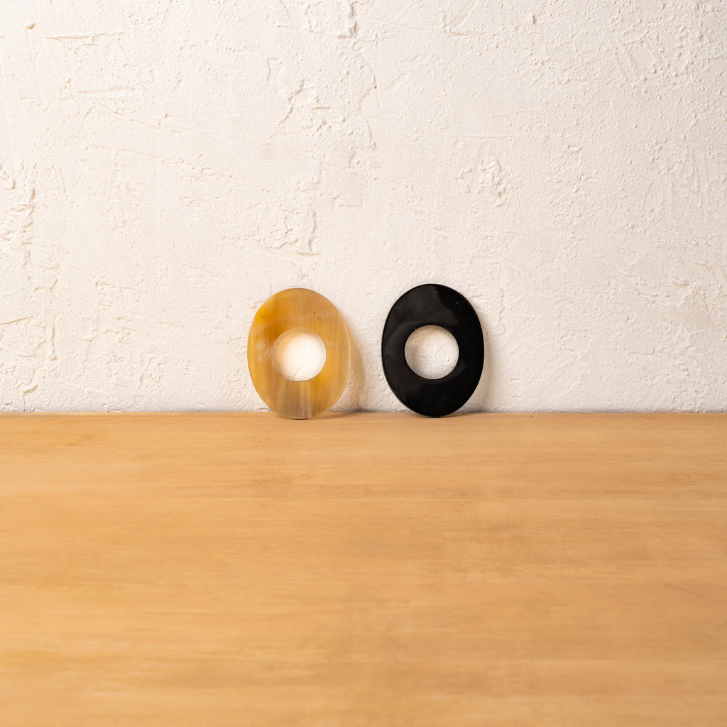 Black and golden Orbit horn napkin rings displayed upright