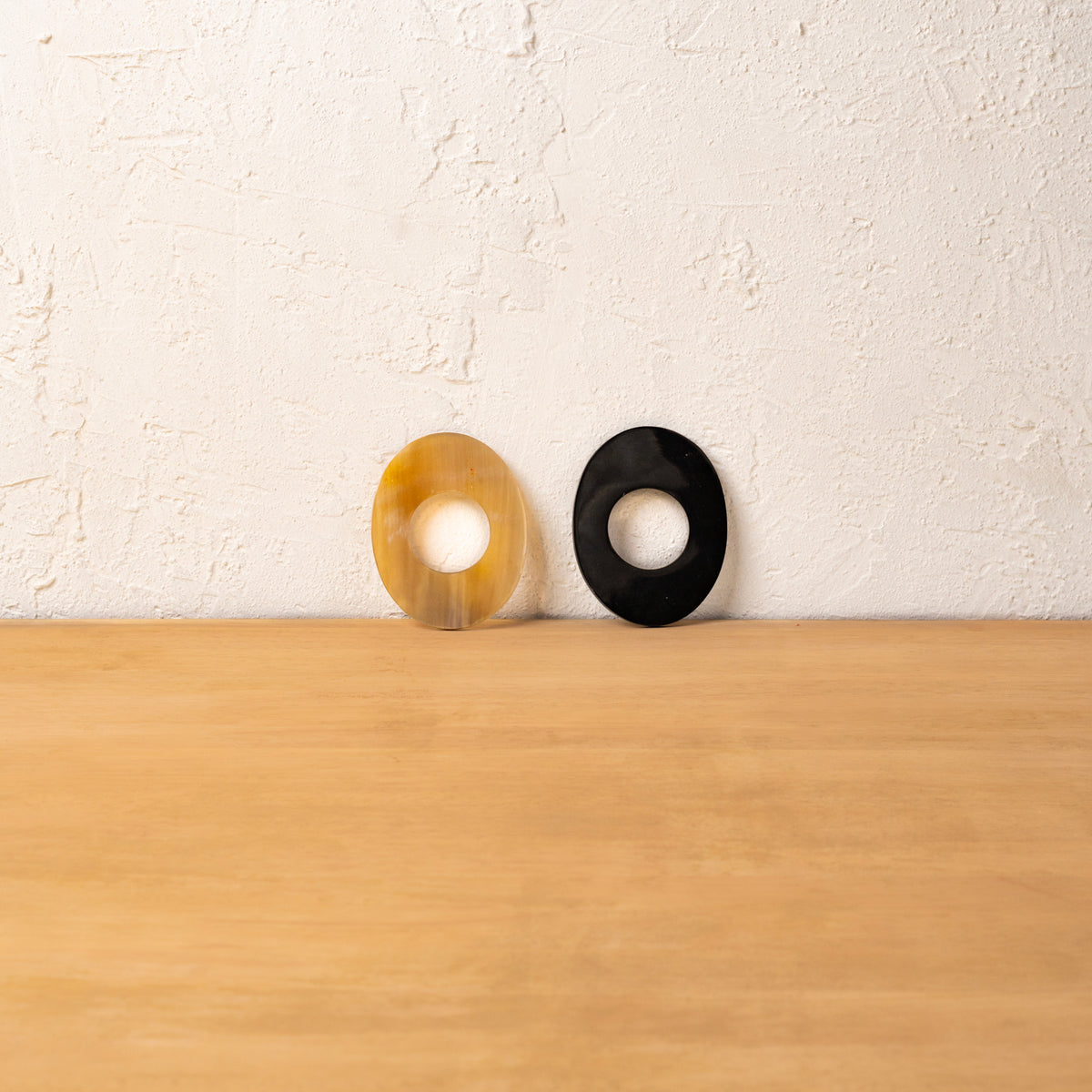 Black and golden Orbit horn napkin rings displayed upright