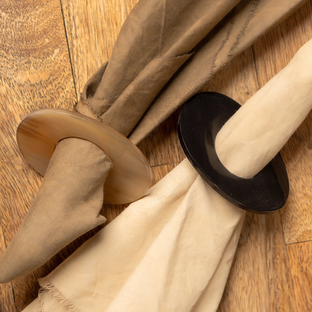 Orbit horn napkin ring holding a folded beige napkin