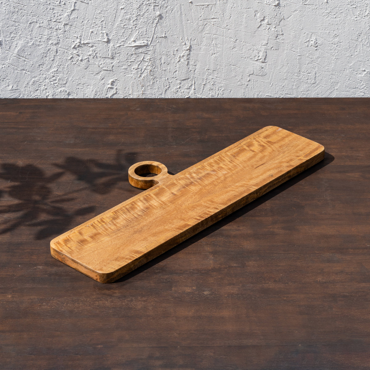Oversized wooden cheese board displayed at an angle