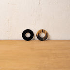 Black and golden Polo horn napkin rings displayed upright