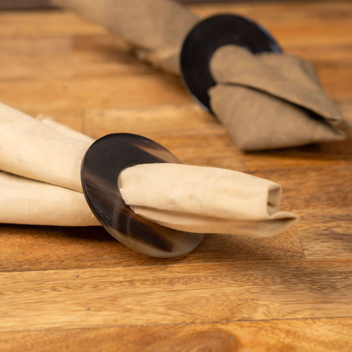 Polo horn napkin ring holding a folded beige napkin