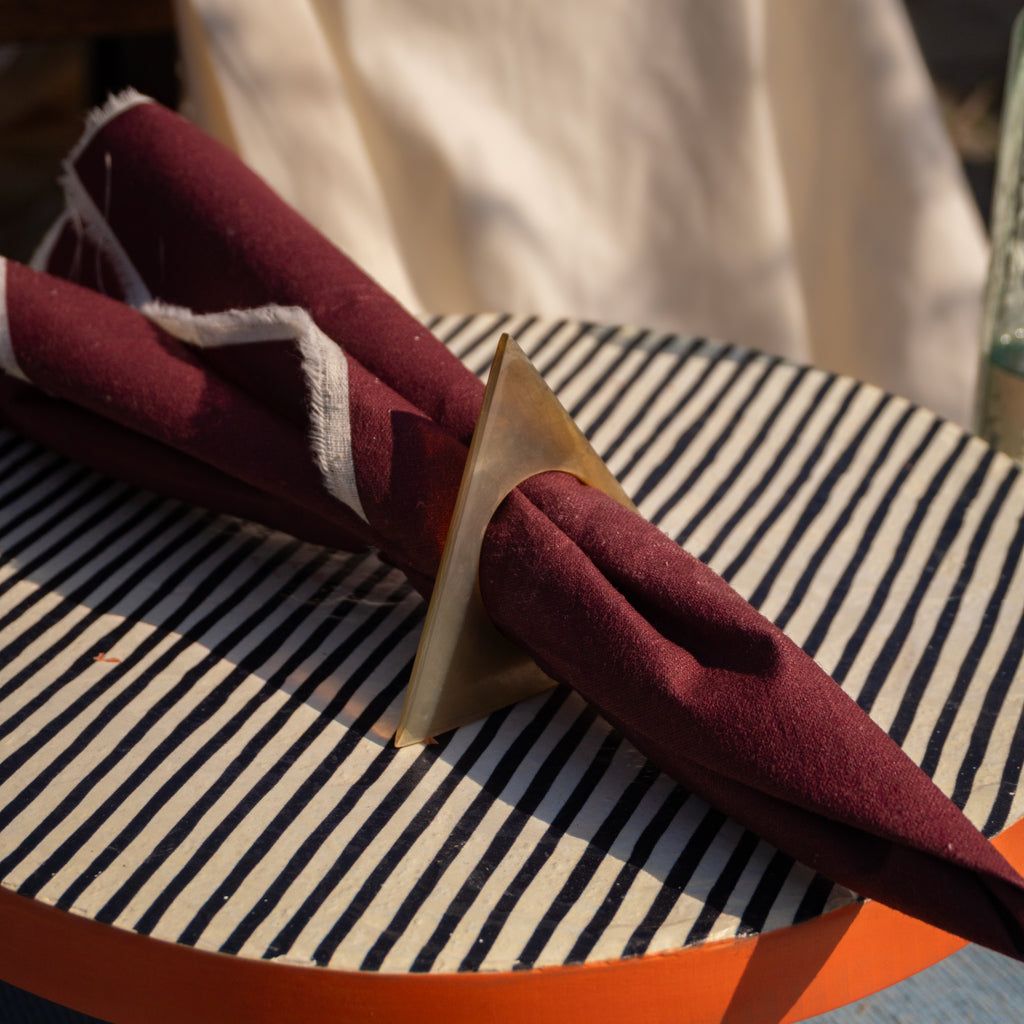 Pyramid horn napkin ring styled with a folded red napkin on a table