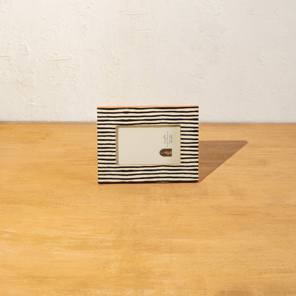 Striped wooden photo frame displayed horizontally on a table